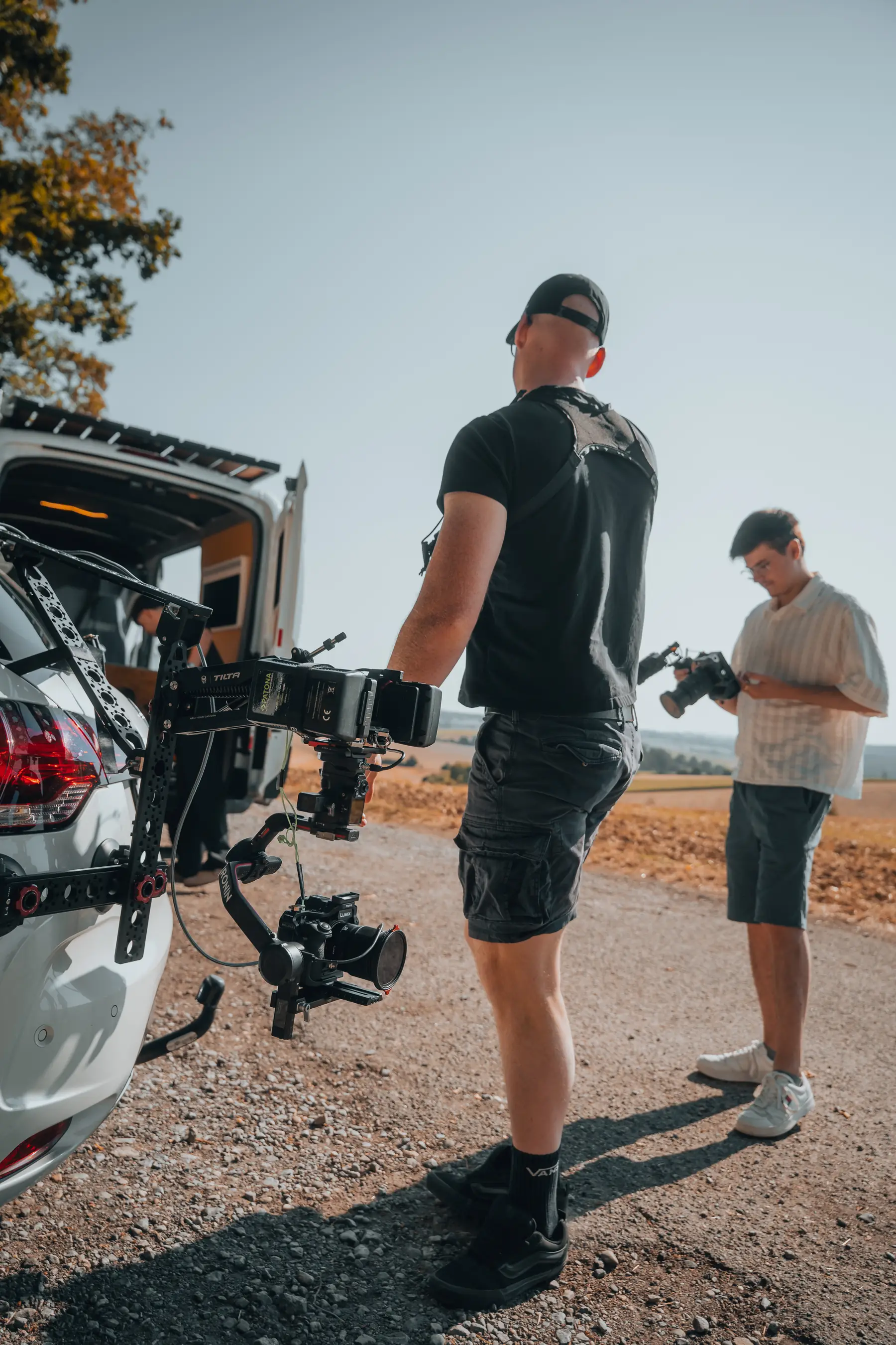 Bastian Obitz und ein Kollege bereiten an einem Fahrzeug ein Car-to-Car-Rig vor